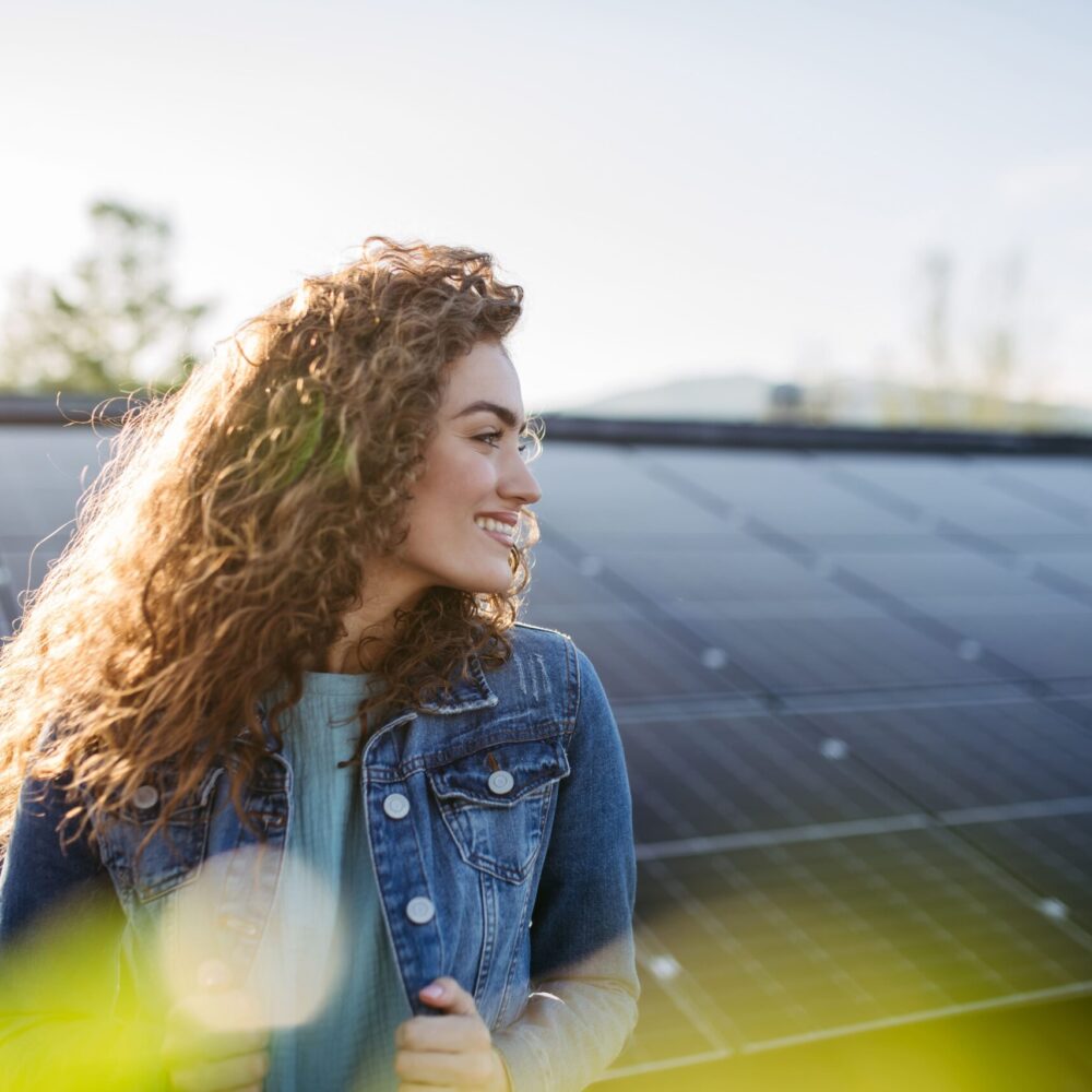 portrait-of-young-woman-on-roof-with-solar-panels-2023-11-27-05-15-45-utc
