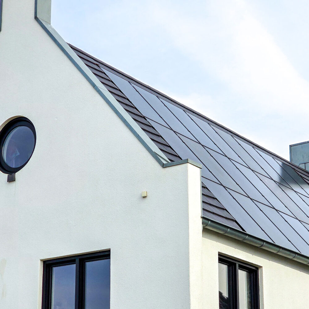 black solar panels on the roof against a sunny sky Close up of a modern home with black solar panels. Zonnepanelen, Zonne energie, Translation: Solar panel, Sun Energy