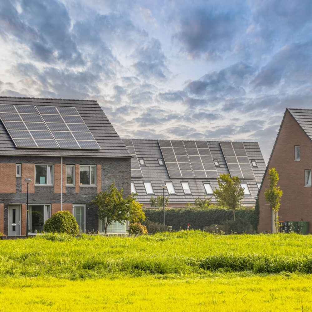 Row of modern family houses in contemporary street. New ecological neighborhood with solar panels. Small  gardens and private parking places. Street view in Heerhugowaard, Netherlands.